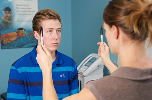 A Boy In Blue Shirt Doing Concussion Rehabilitation Exercise With His Therapist